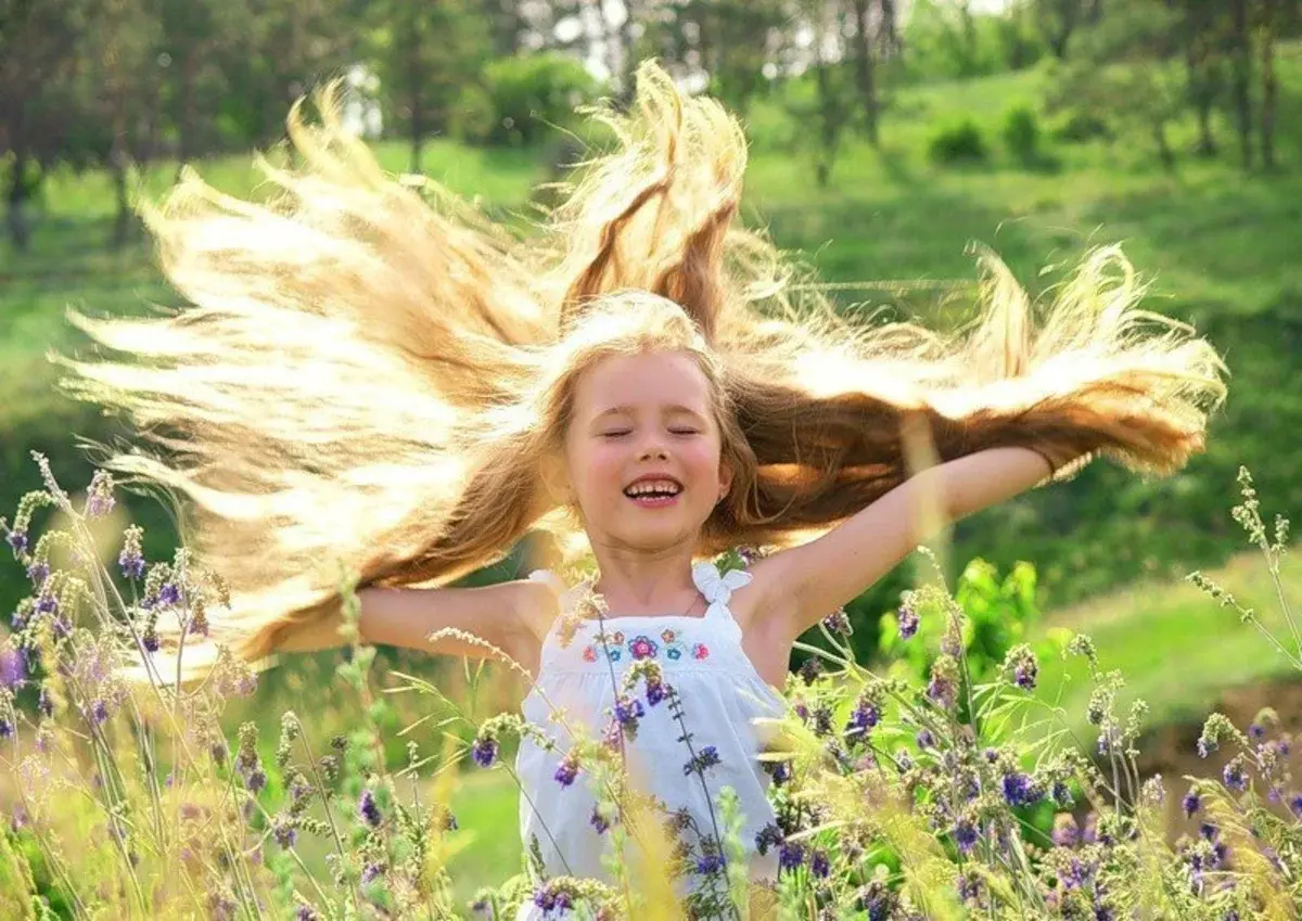 В саду гуляет ветер. Дети радуются. Счастливый ребенок. Легкий ветер. Дети радуются солнцу.